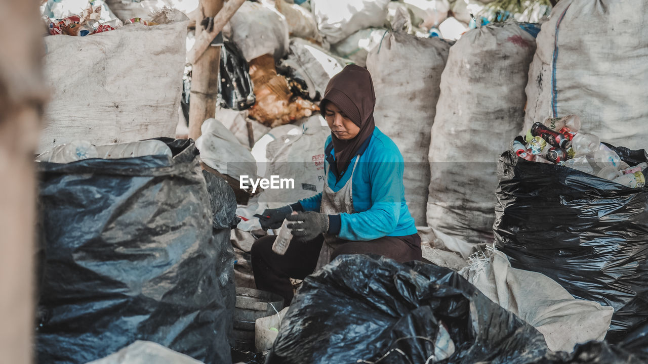 A female worker recycles plastic bottle waste at a plastic waste management site in malang city. 