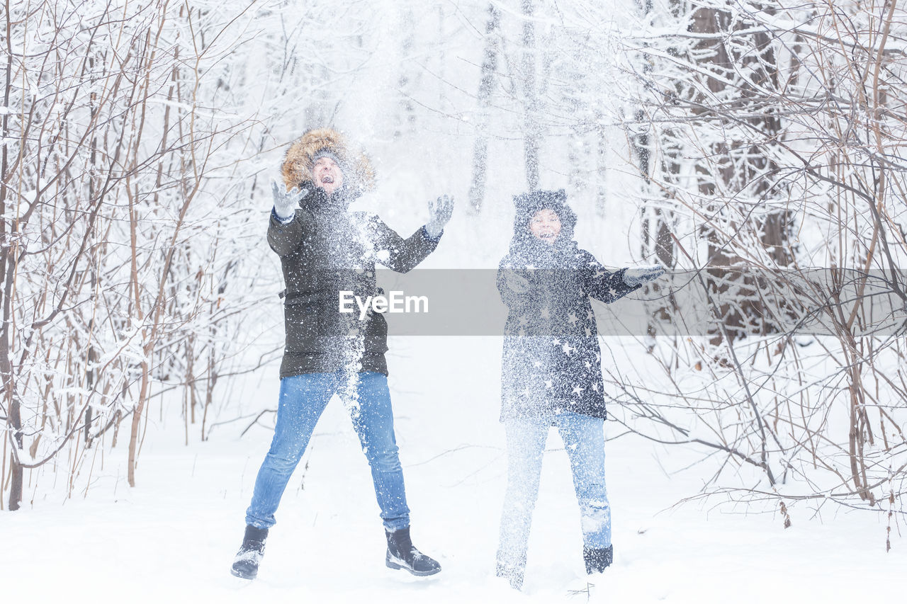 VIEW OF TWO PEOPLE ON SNOW COVERED LAND