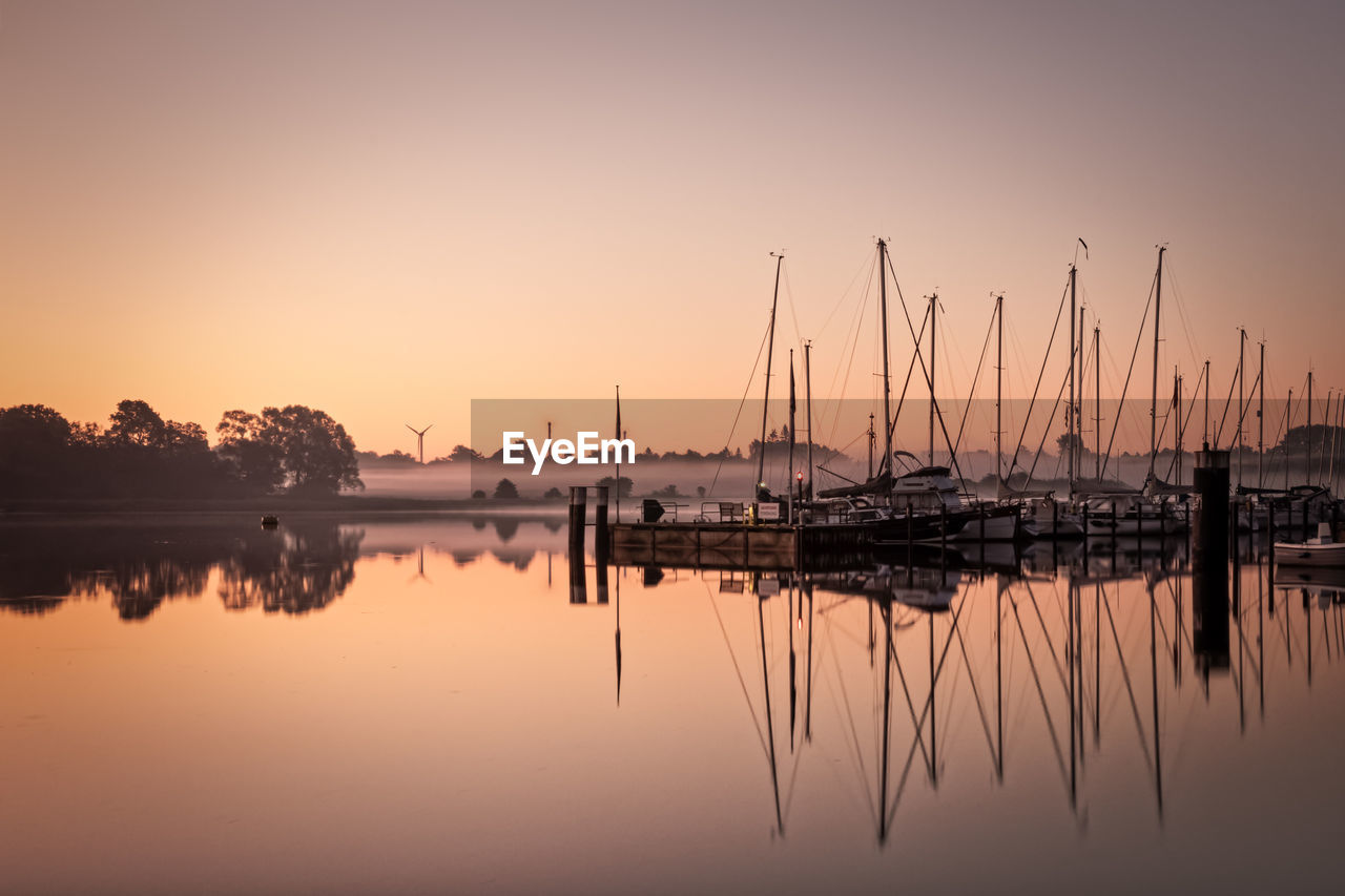 Sailboats in marina at sunset