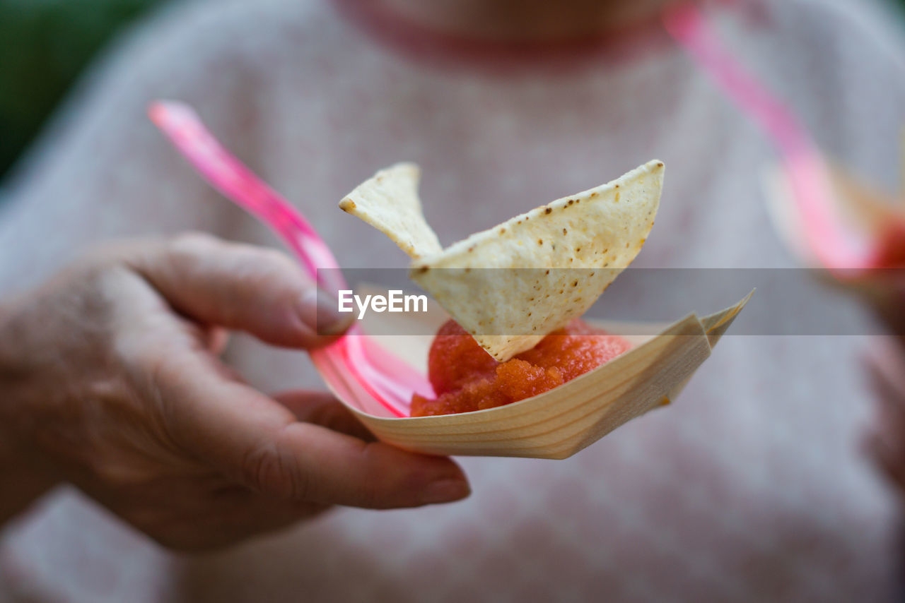 Midsection of woman holding snack in paper plate