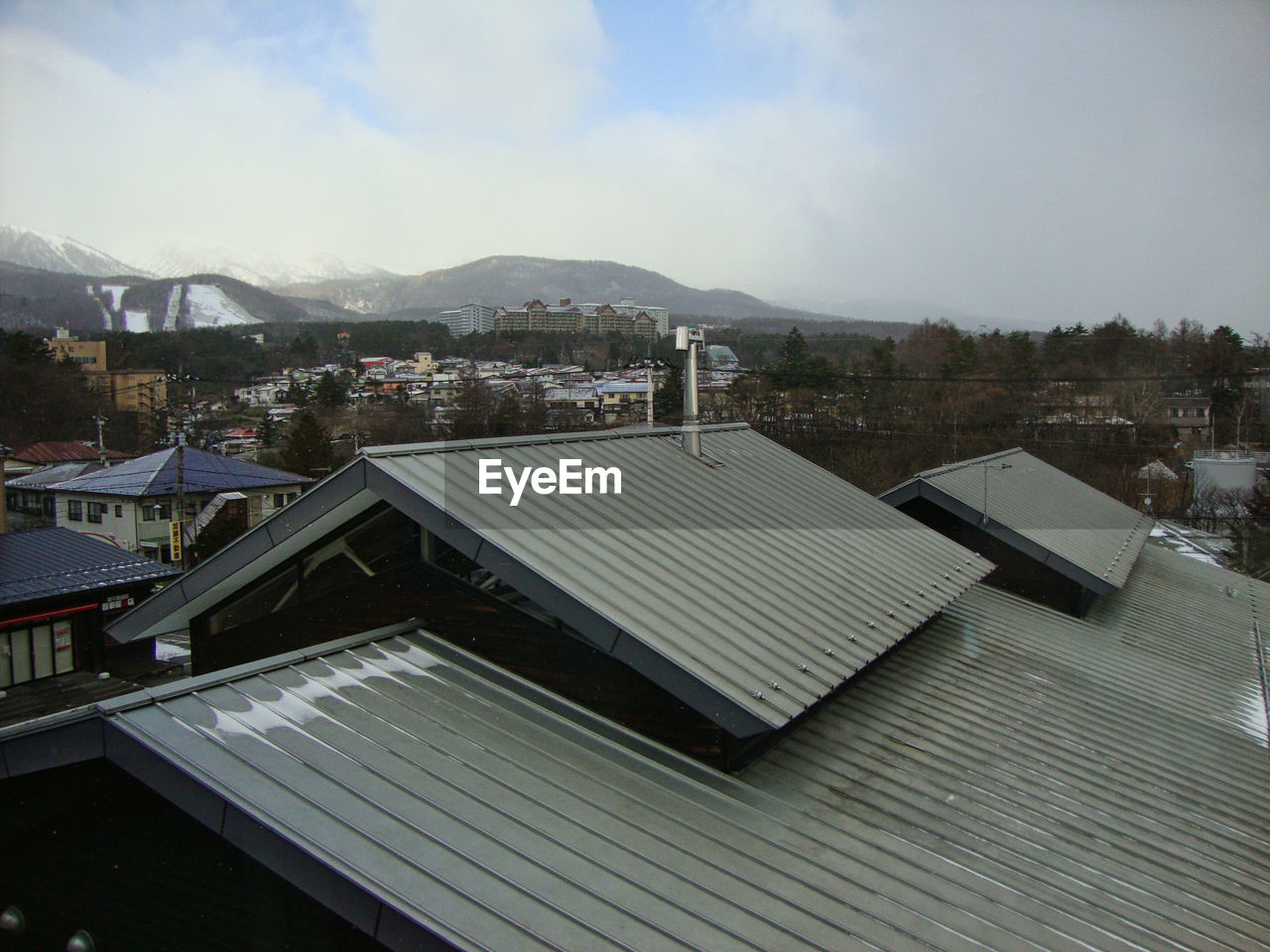 HIGH ANGLE VIEW OF HOUSES AND BUILDINGS AGAINST SKY