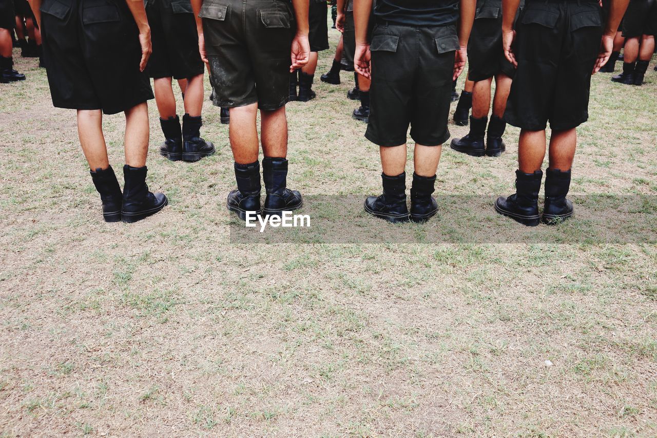 Low section of children wearing uniforms standing on land