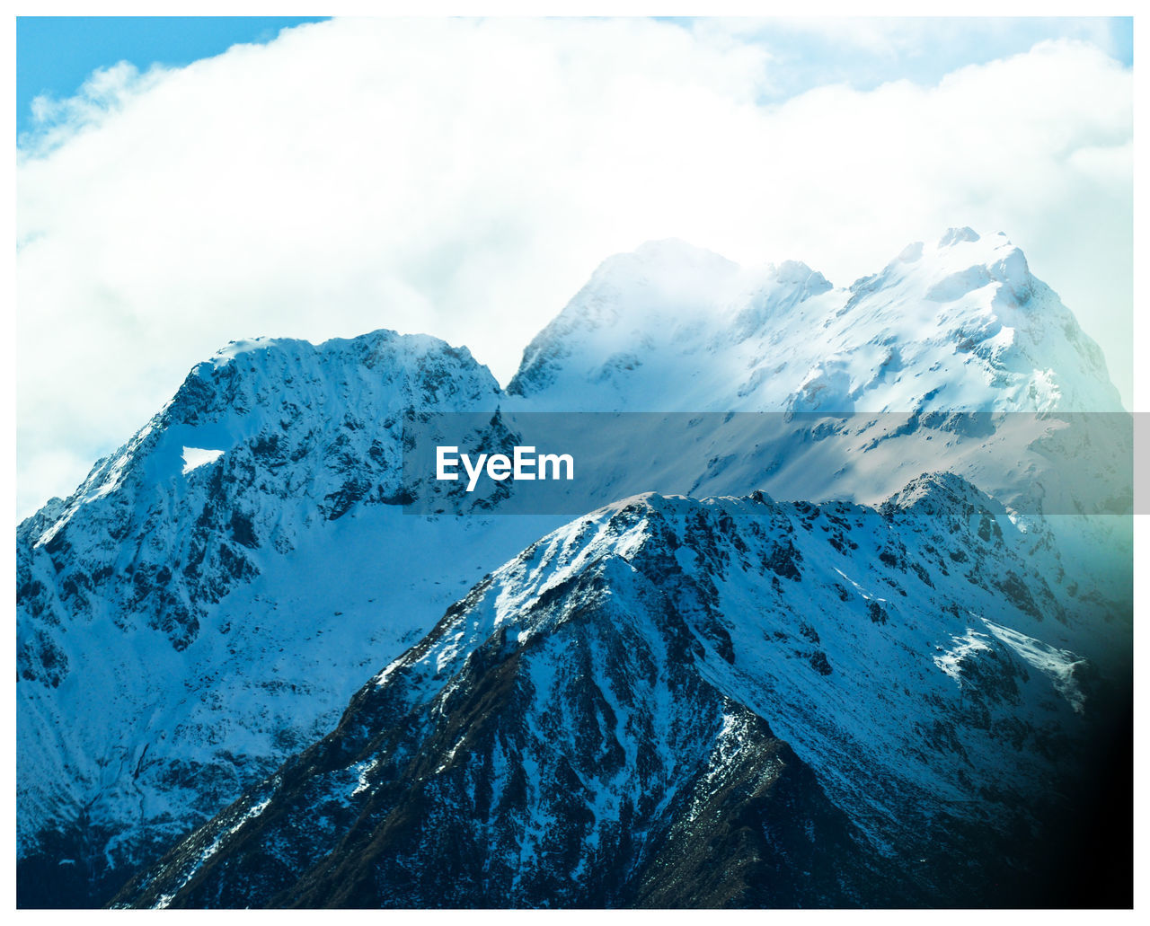 SNOW COVERED MOUNTAINS AGAINST SKY