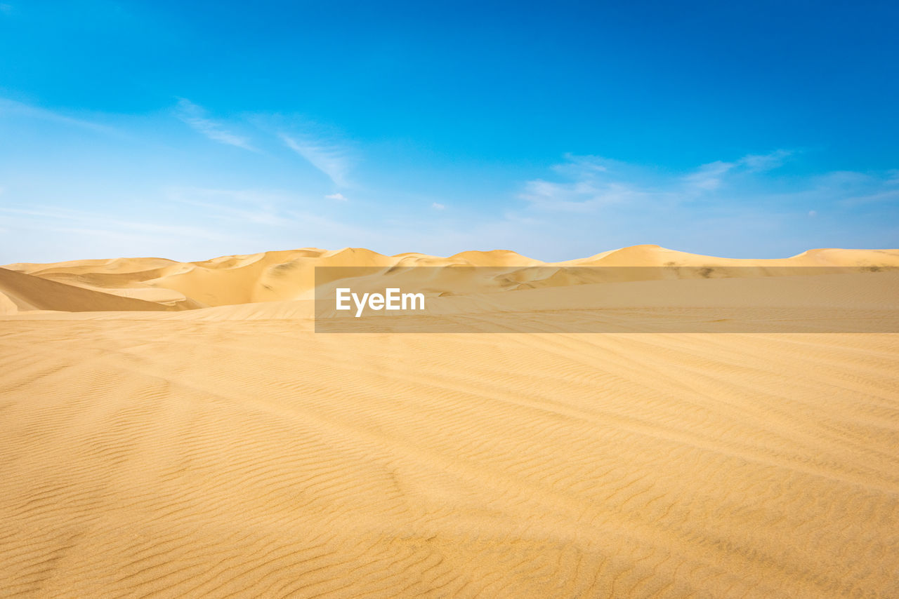 Scenic view of desert against blue sky