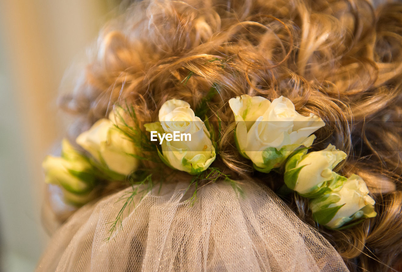 Close-up of bride hair with roses on shoulder