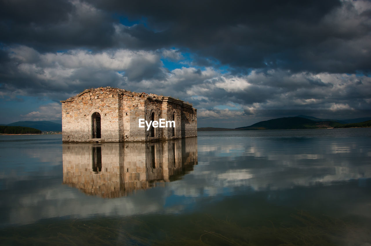 Reflection of building in lake against sky