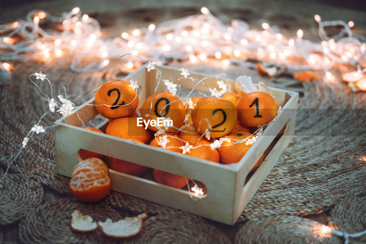 Christmas greeting card with oranges, tangerines  black numbers 2021 written on oranges.