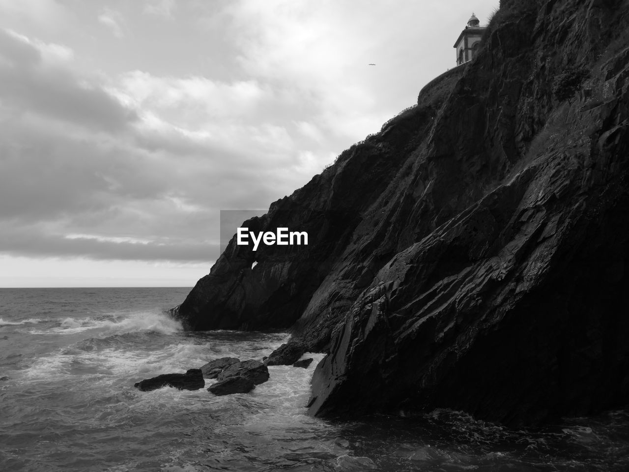 Rock formation on beach against sky