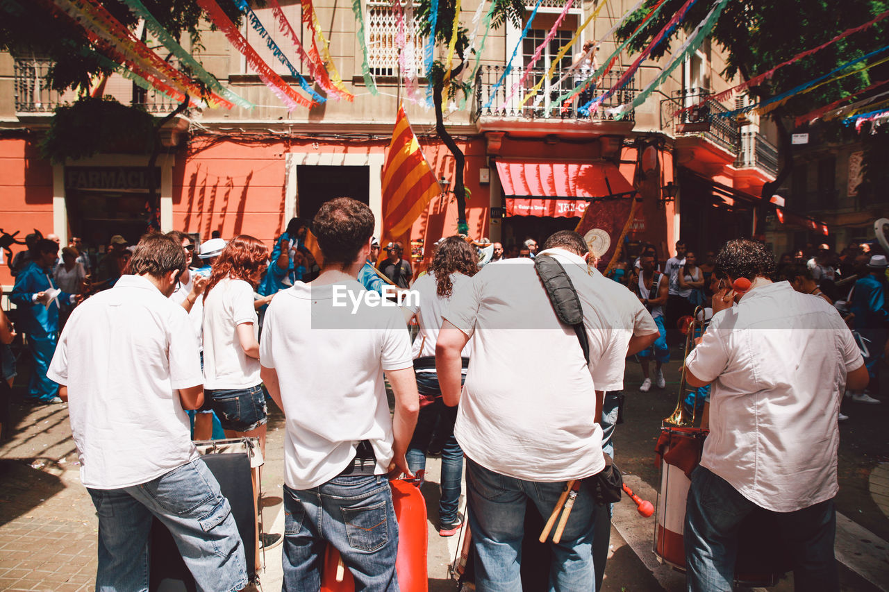 Rear view of men performing at festa major de gracia in city