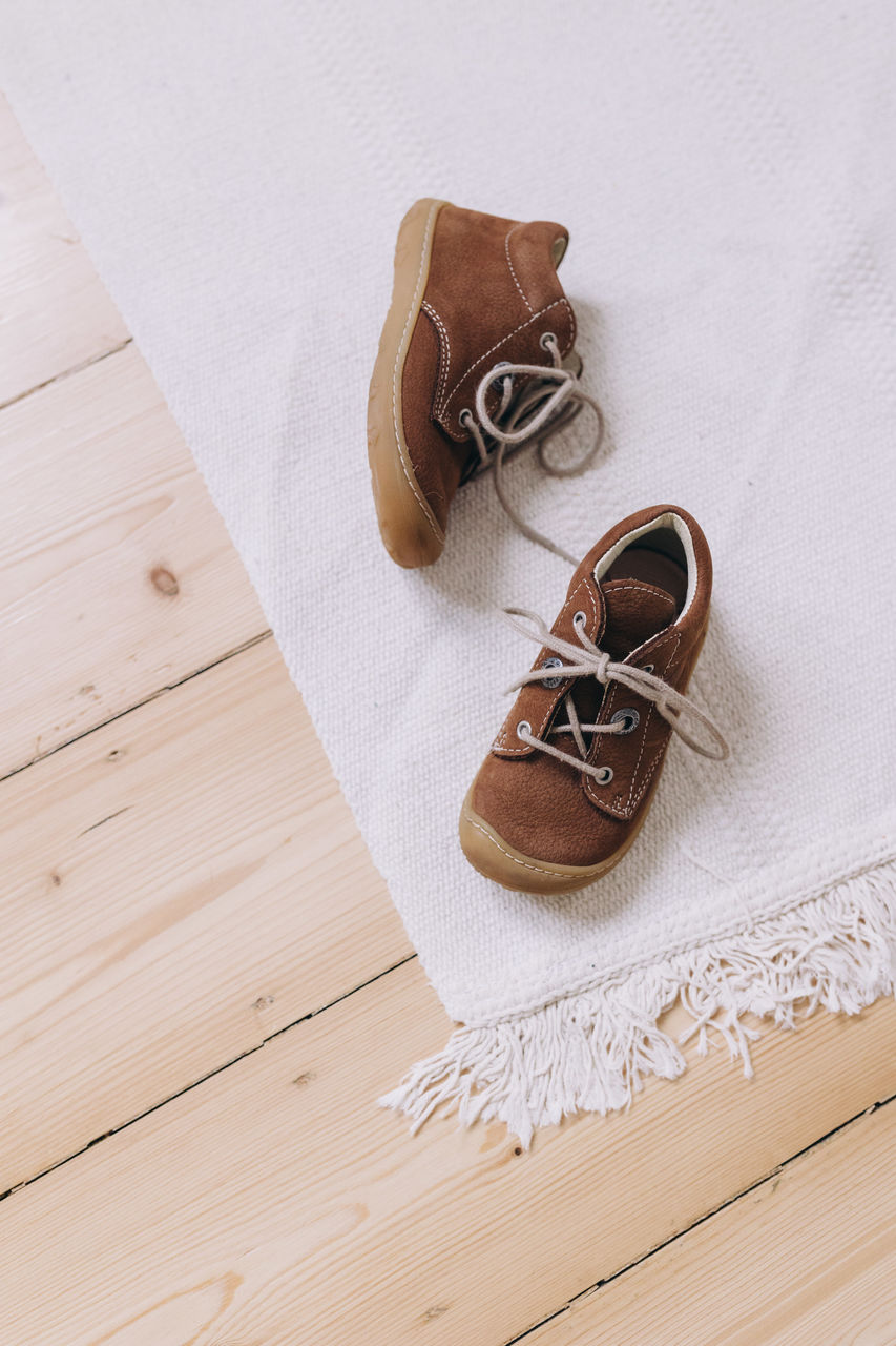 High angle view of children shoes on a white carpet