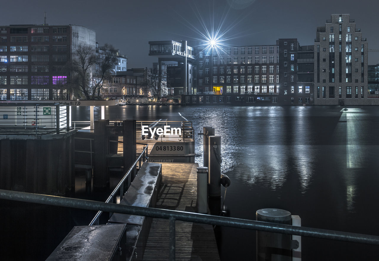 View of illuminated buildings by river