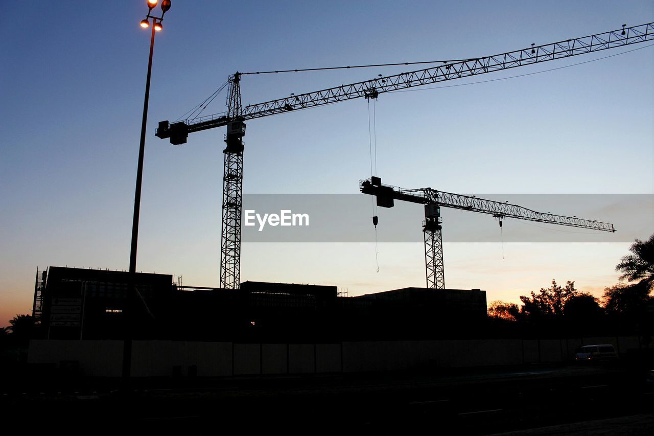 Low angle view of cranes at construction site