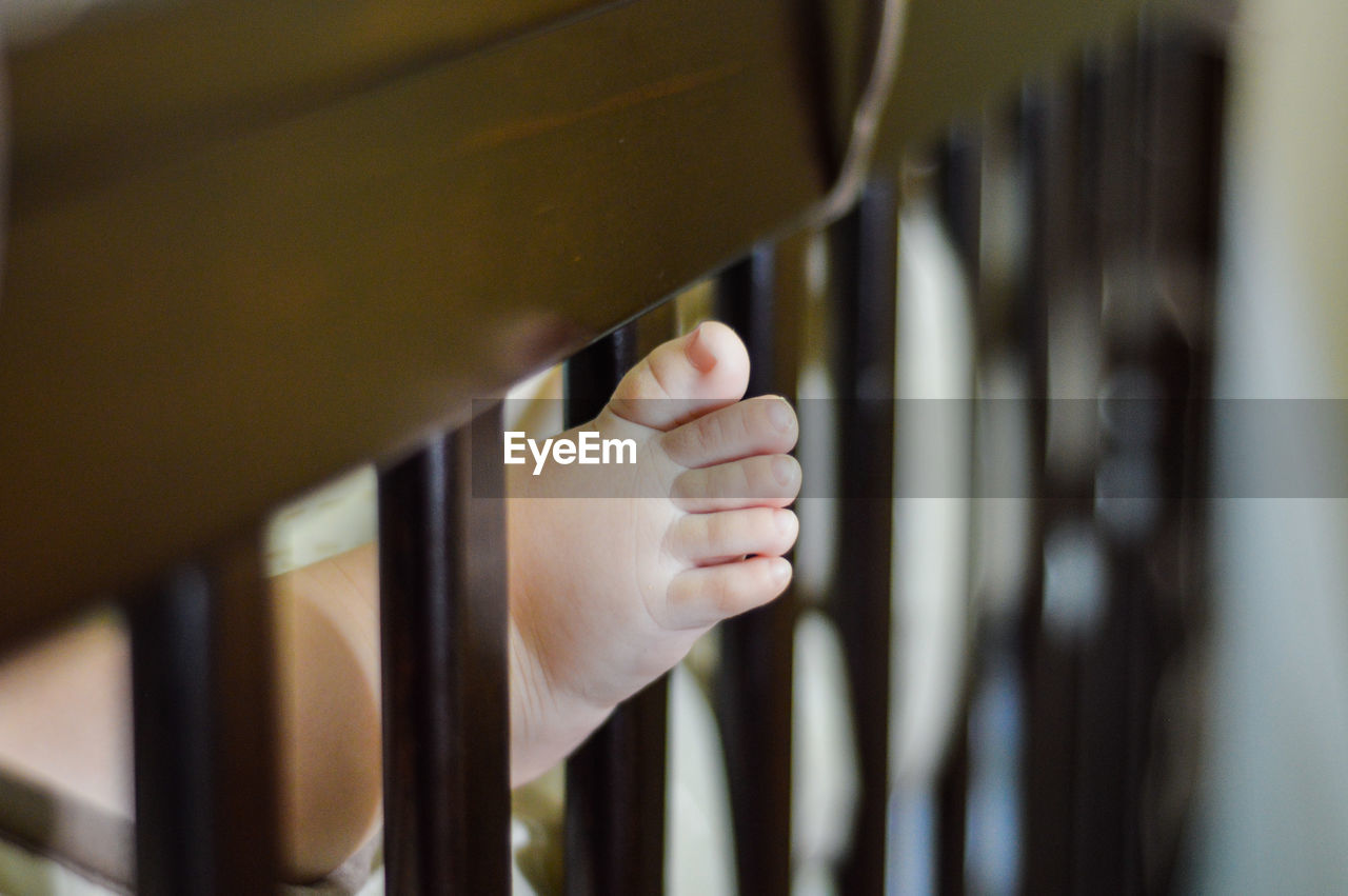Close-up of baby foot in crib