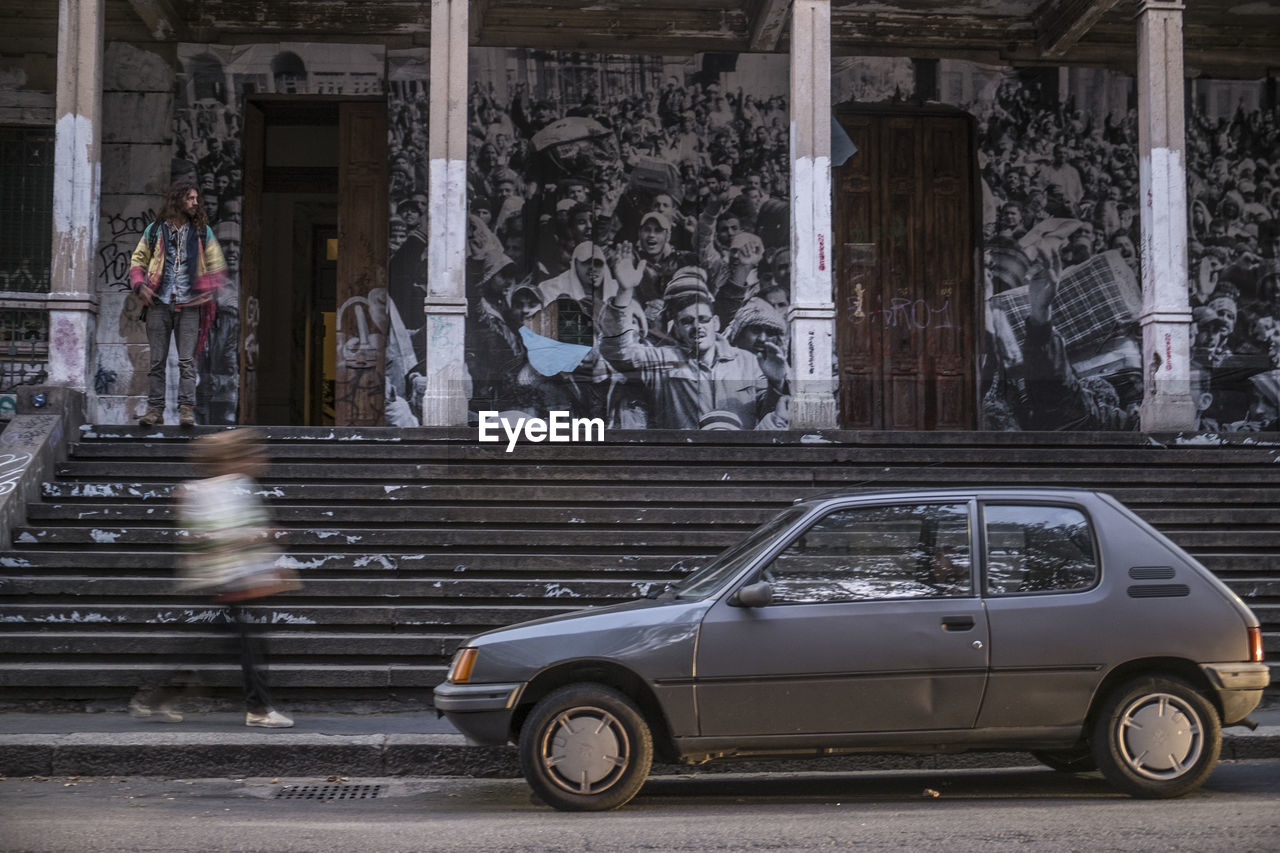 CAR ON STREET AGAINST BUILDING