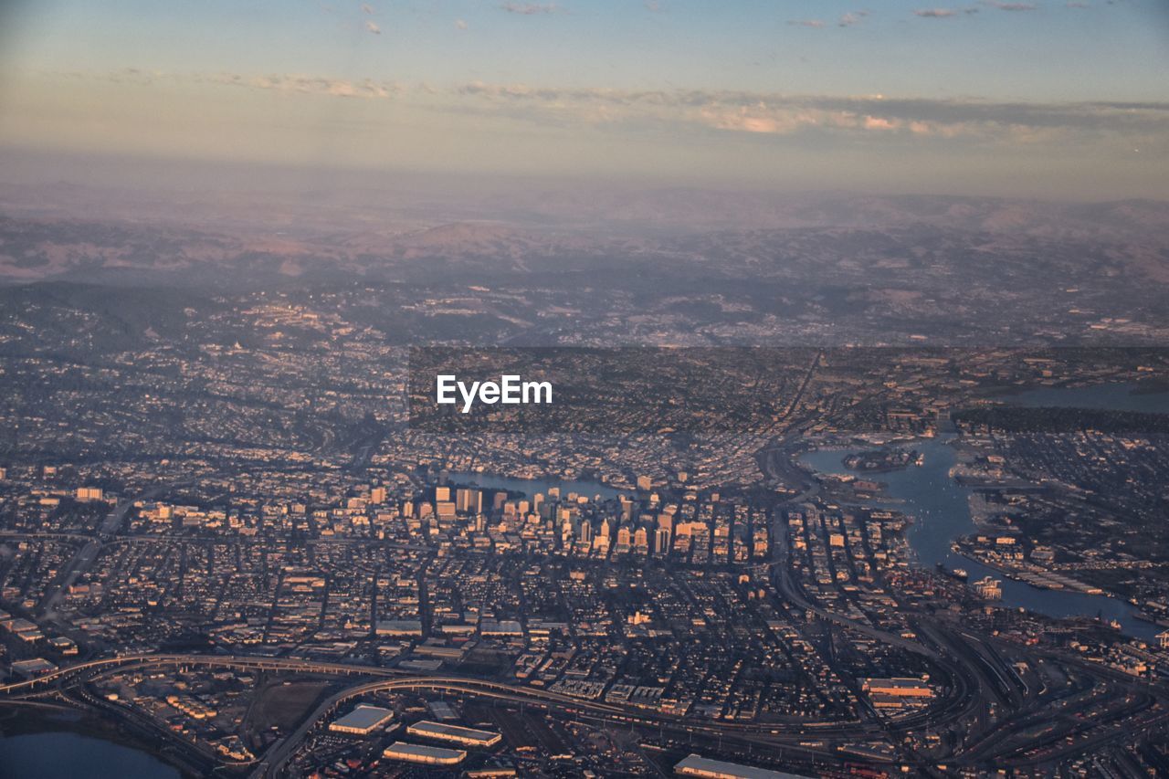 aerial photography, city, horizon, architecture, cityscape, aerial view, building exterior, built structure, sky, dusk, building, nature, landscape, transportation, travel destinations, high angle view, evening, flying, cloud, urban skyline, no people, travel, air vehicle, airplane, outdoors, sunset, skyline, environment, reflection, city life, residential district, urban area, office building exterior, skyscraper, mode of transportation, business finance and industry, scenics - nature, bird's-eye view