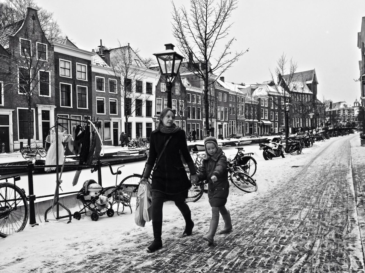 WOMAN WALKING ON SNOW COVERED CITY