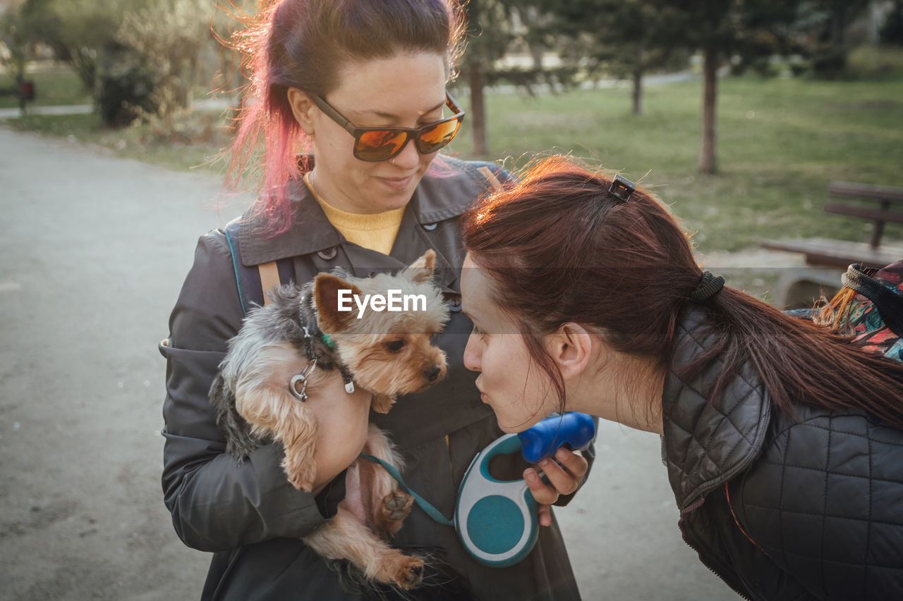 Woman puckering at friend dog on road