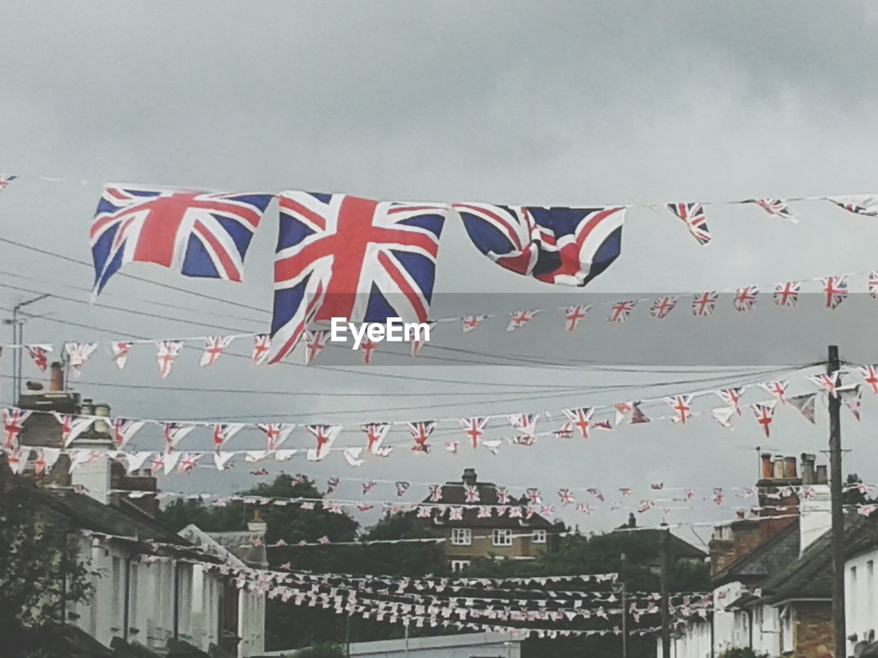 Low angle view of british flags against cloudy sky