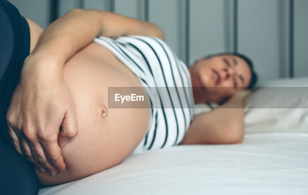 Pregnant woman lying on bed