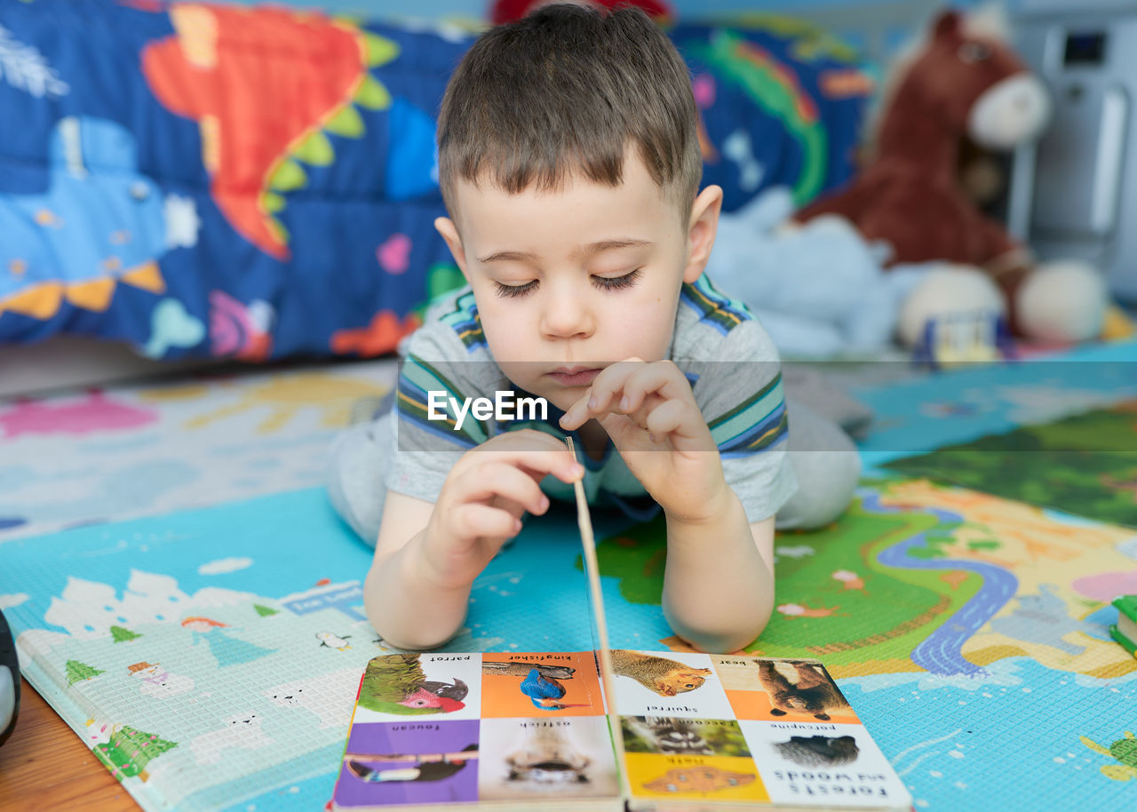 childhood, child, one person, men, creativity, indoors, multi colored, learning, concentration, front view, toddler, baby, portrait, leisure activity, toy, table, paint, looking, looking down, innocence, lifestyles, holding, brush, education, brown hair, cute, paintbrush, activity, headshot