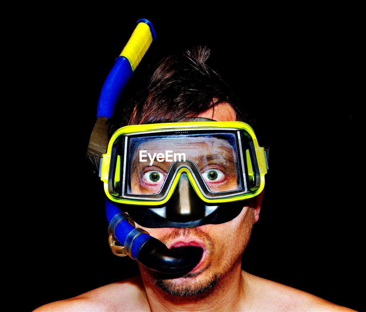 Portrait of man wearing scuba mask against black background