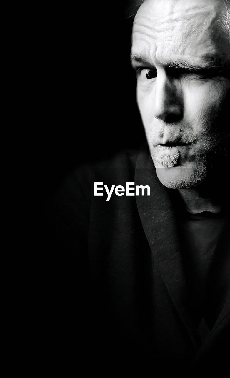 PORTRAIT OF YOUNG MAN WEARING BLACK BACKGROUND