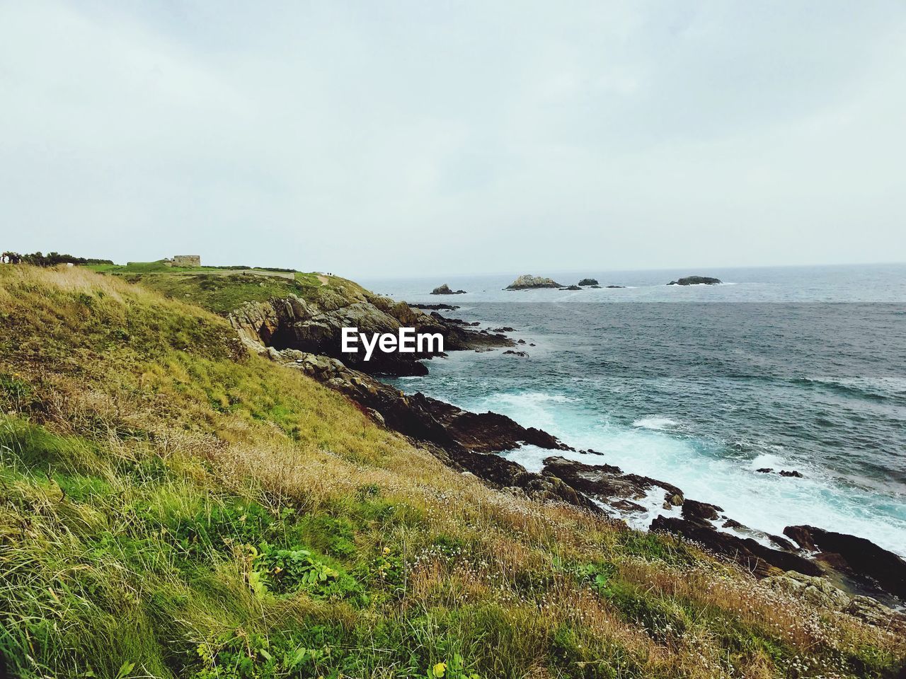 Scenic view of sea and cliff against sky