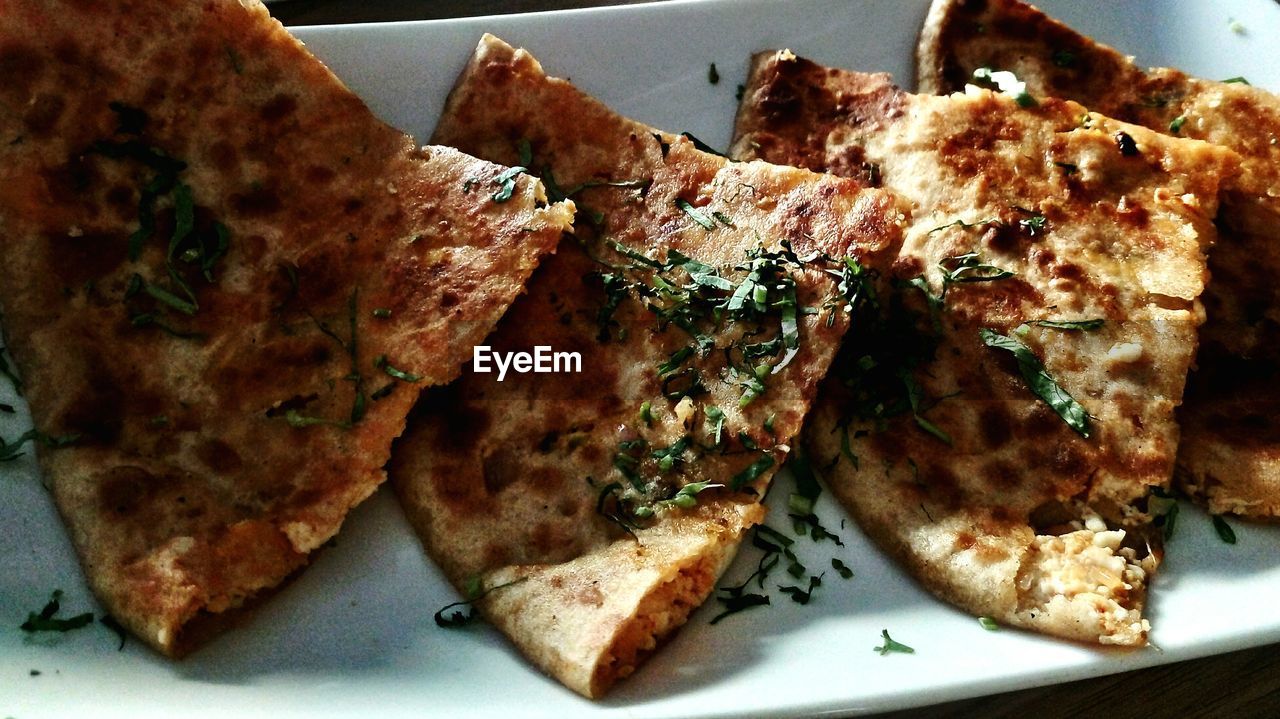 High angle view of fresh cheese parathas served in plate