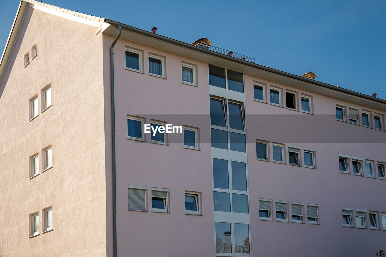 LOW ANGLE VIEW OF RESIDENTIAL BUILDING AGAINST SKY