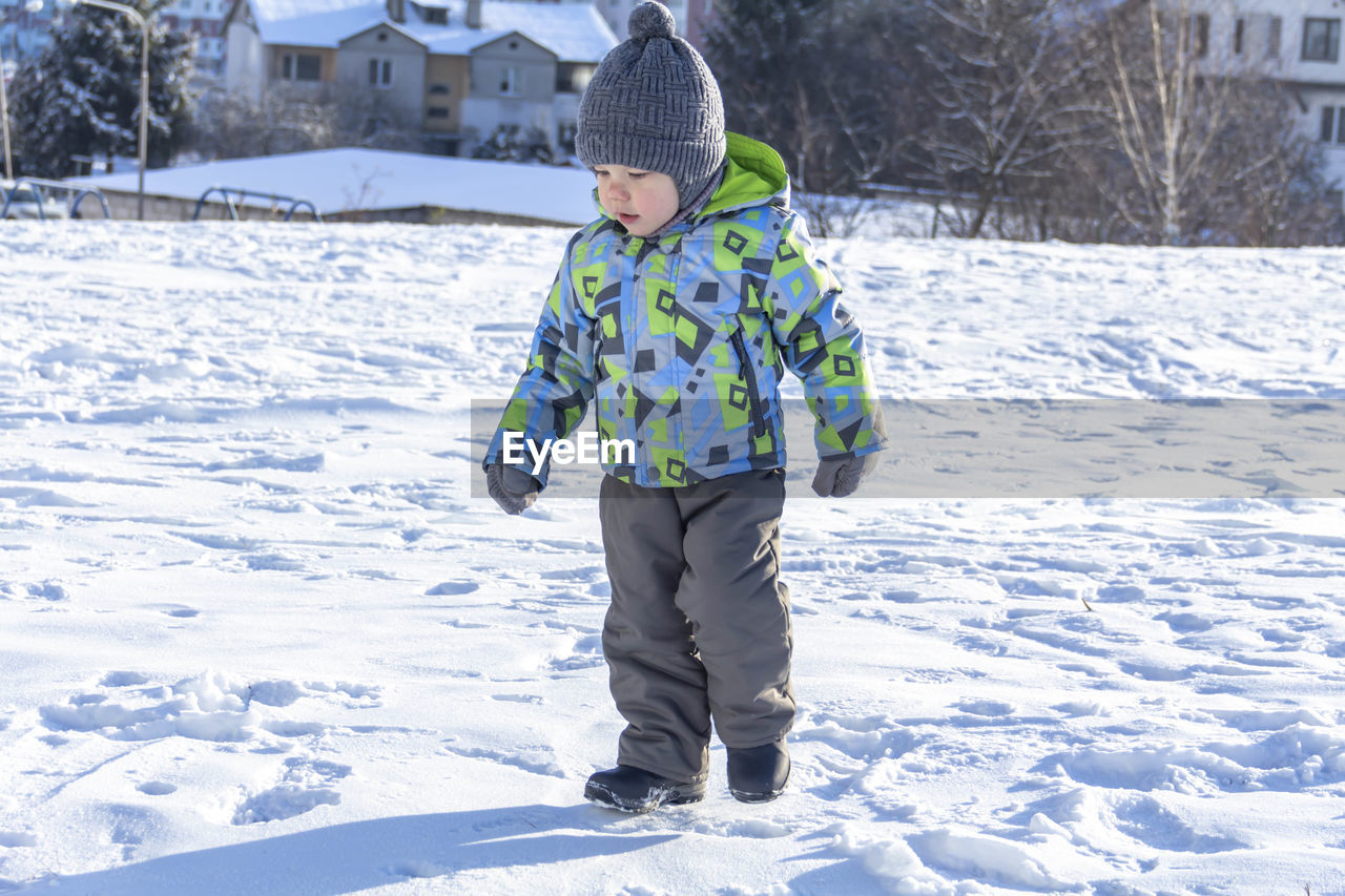 Full length of boy walking on snow covered land