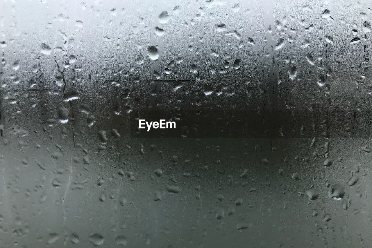 FULL FRAME SHOT OF RAINDROPS ON GLASS