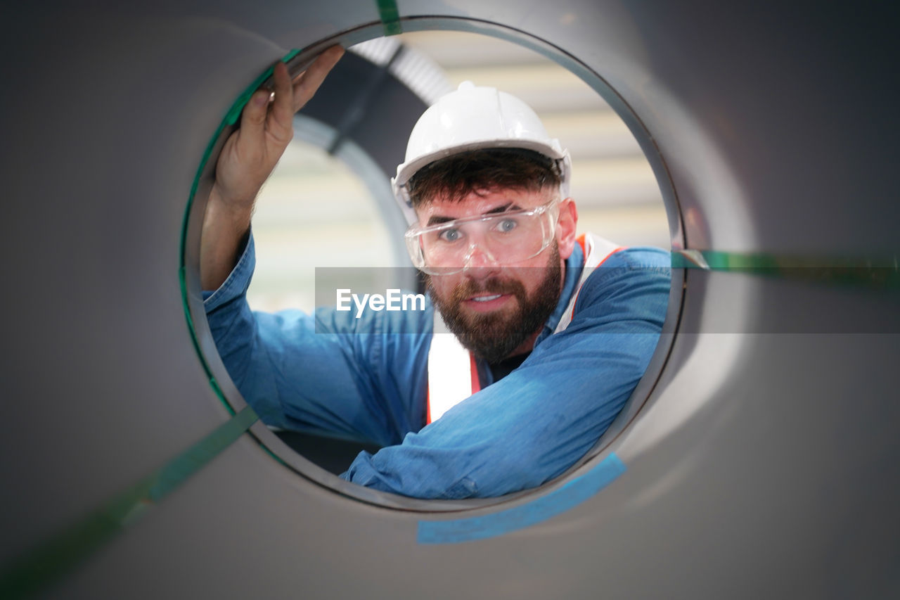 one person, adult, men, occupation, portrait, indoors, beard, expertise, working, facial hair, blue, protection, scrutiny, person, industry, looking, technology, science, skill, protective workwear, headshot, glasses, technician, mature adult, examining, concentration