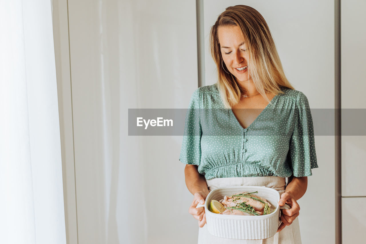 Young european woman holding a tray with food and smiling