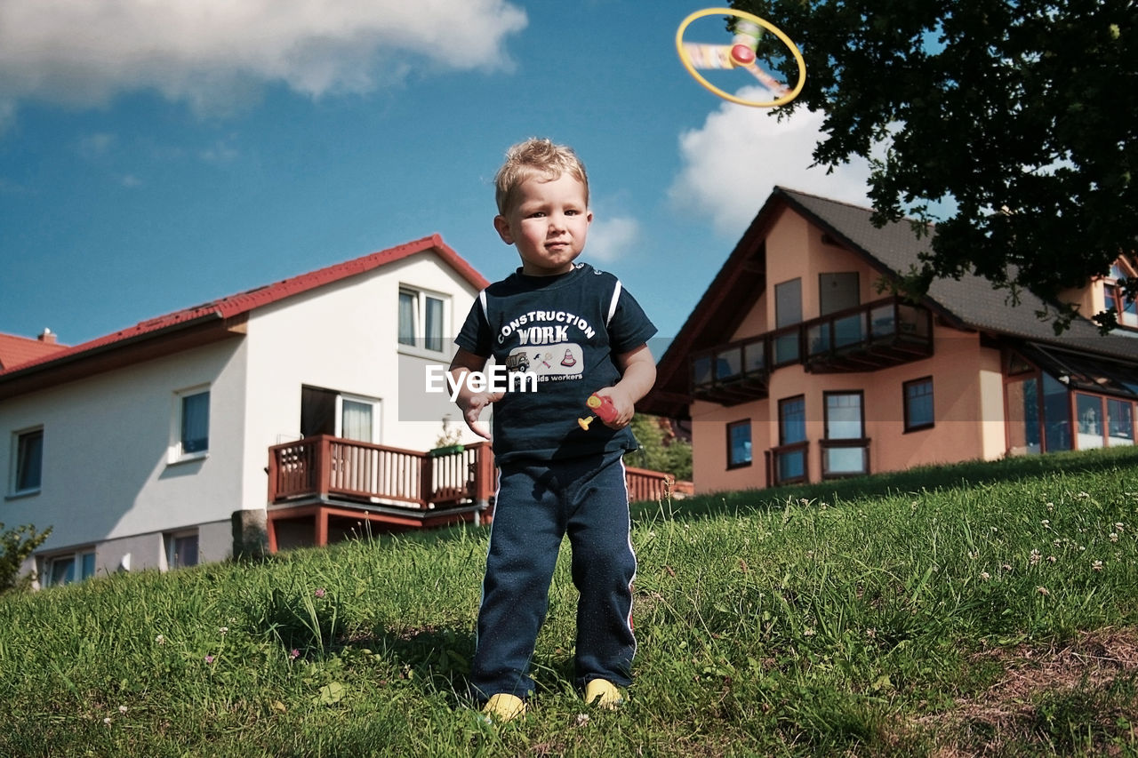 Portrait of boy playing with toy in yard