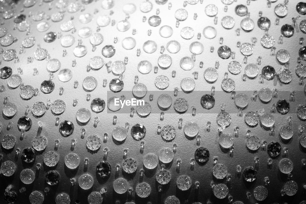 FULL FRAME SHOT OF RAINDROPS ON WET WINDSHIELD