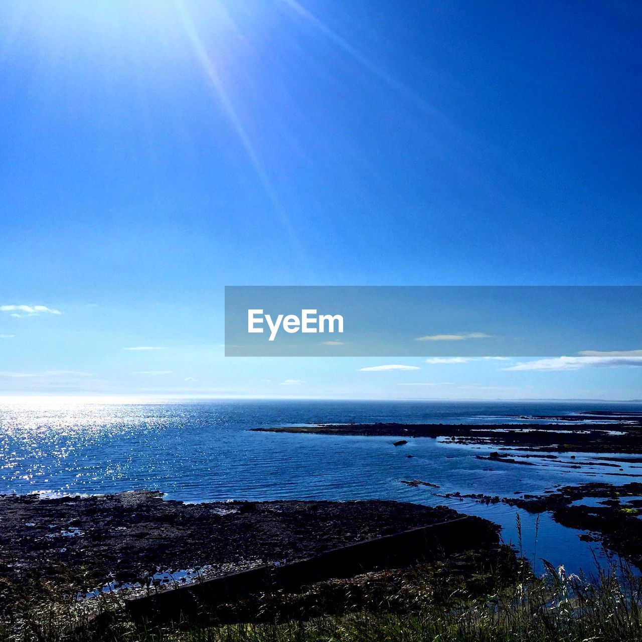 Scenic view of sea against blue sky