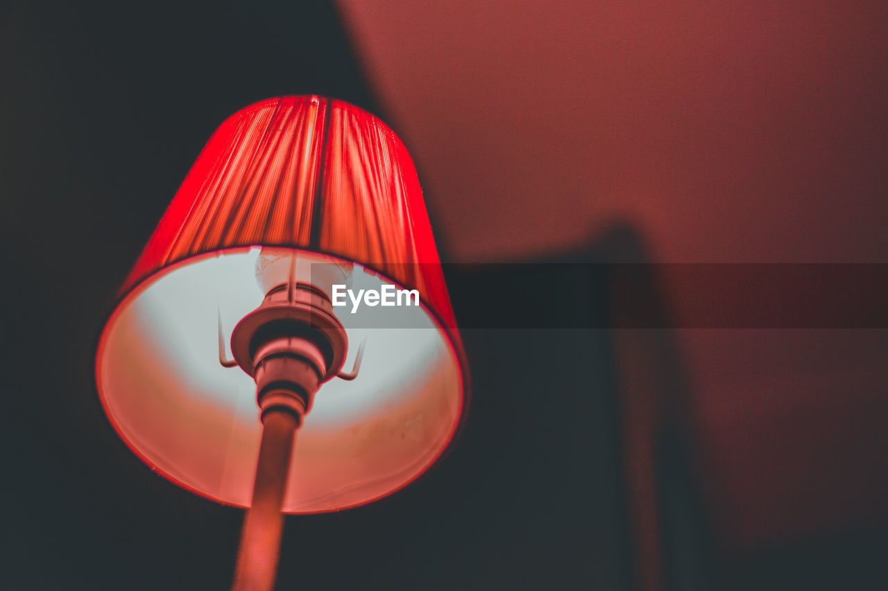 Low angle view of illuminated lamp in darkroom