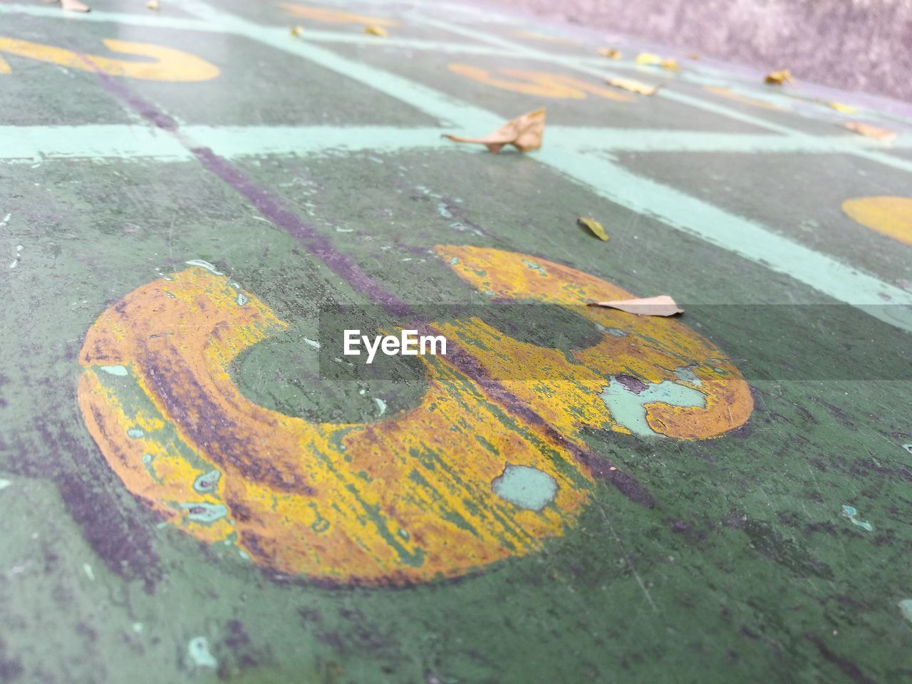 HIGH ANGLE VIEW OF ARROW SYMBOL ON WET STREET