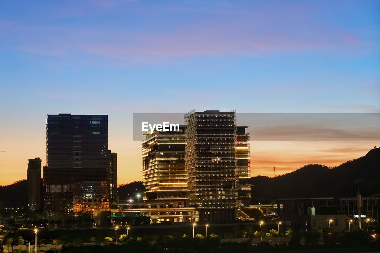 ILLUMINATED BUILDINGS AGAINST SKY DURING SUNSET