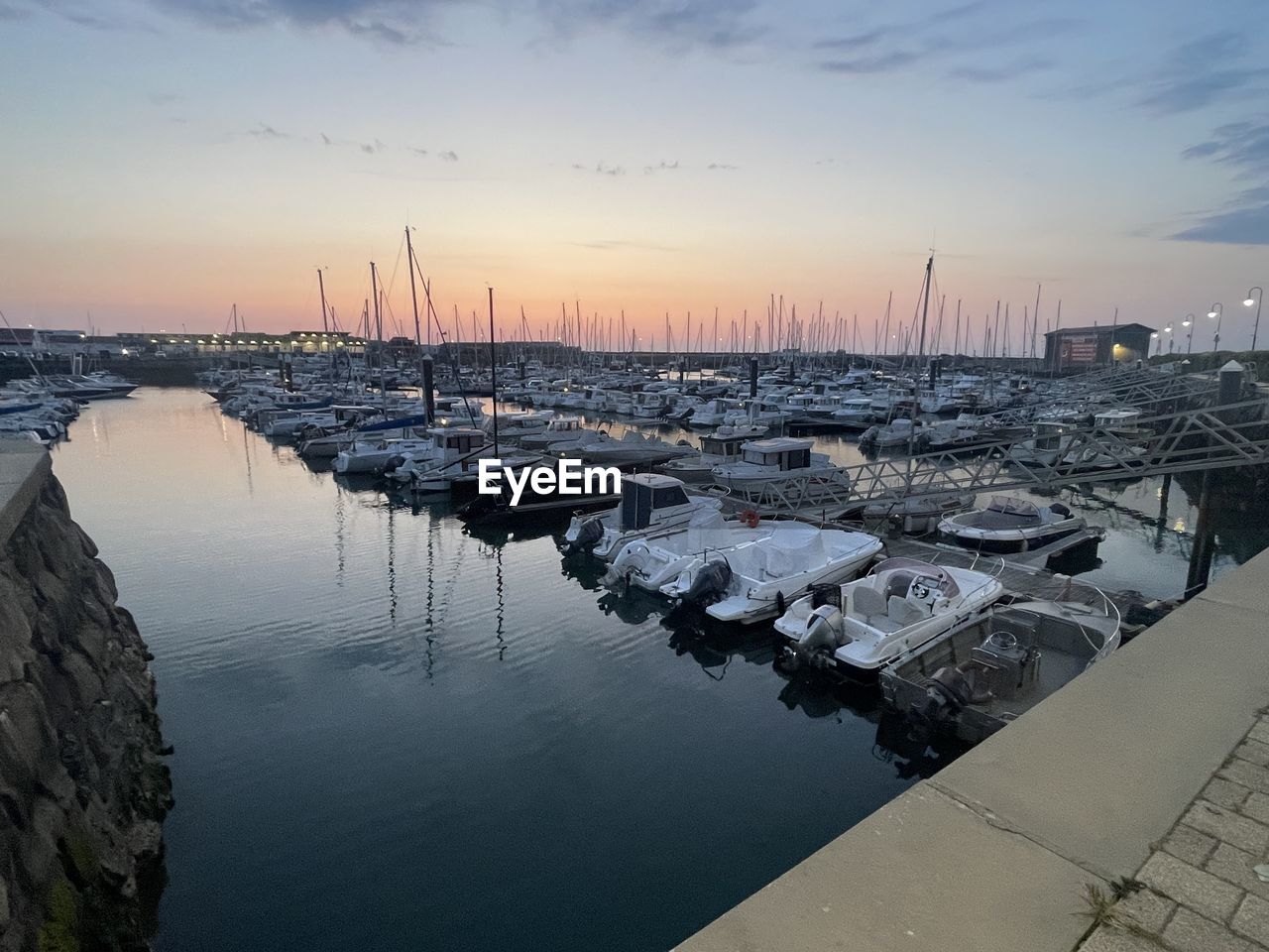 water, dock, nautical vessel, sky, transportation, marina, harbor, reflection, sunset, sea, architecture, city, nature, mode of transportation, port, ship, no people, travel destinations, coast, cloud, built structure, pier, boat, beauty in nature, vehicle, moored, bay, travel, building exterior, landscape, outdoors, environment, sailboat, scenics - nature, twilight, building, tranquility, dusk, cityscape, sun, horizon, shore, watercraft