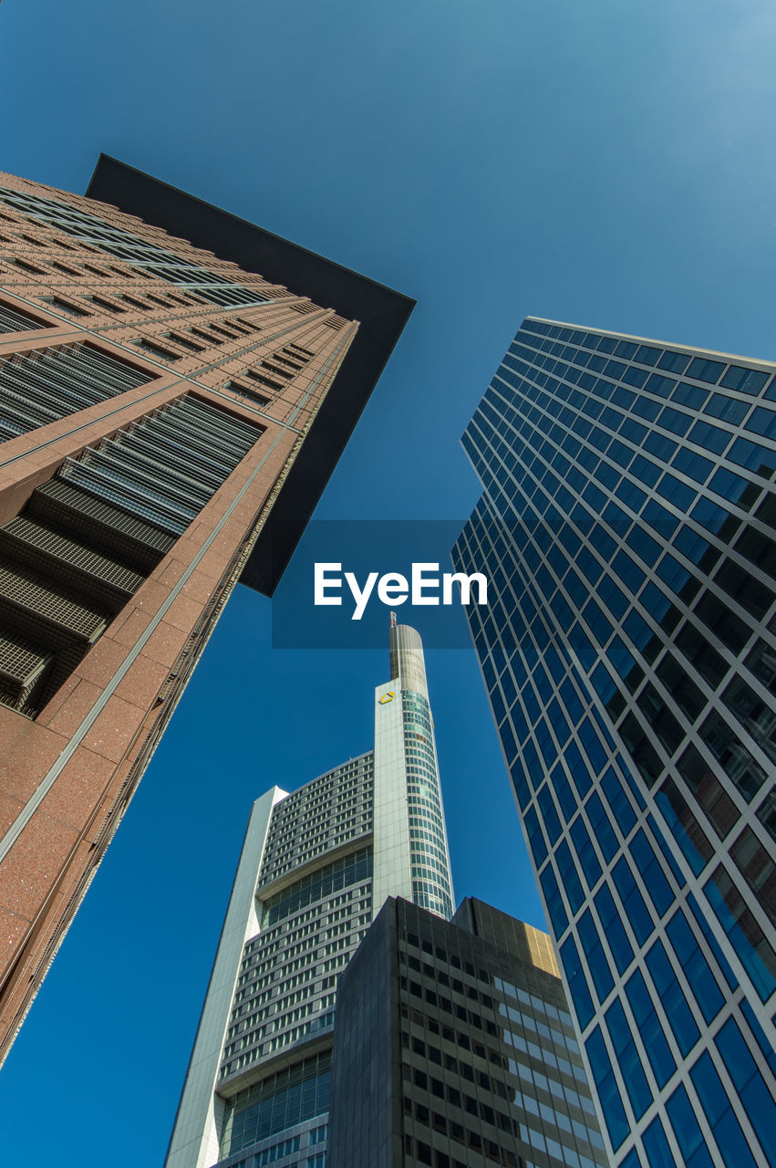 Low angle view of modern buildings against clear blue sky