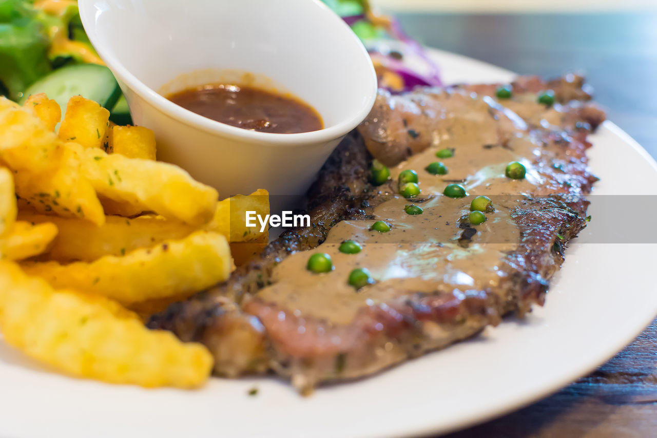 Meat and curry with french fries on plate