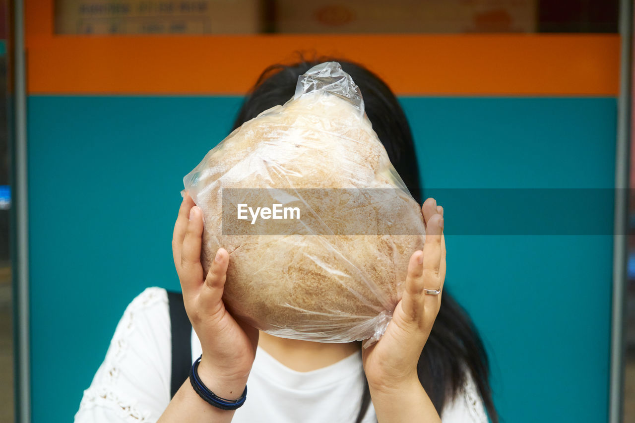 Woman covering face with food