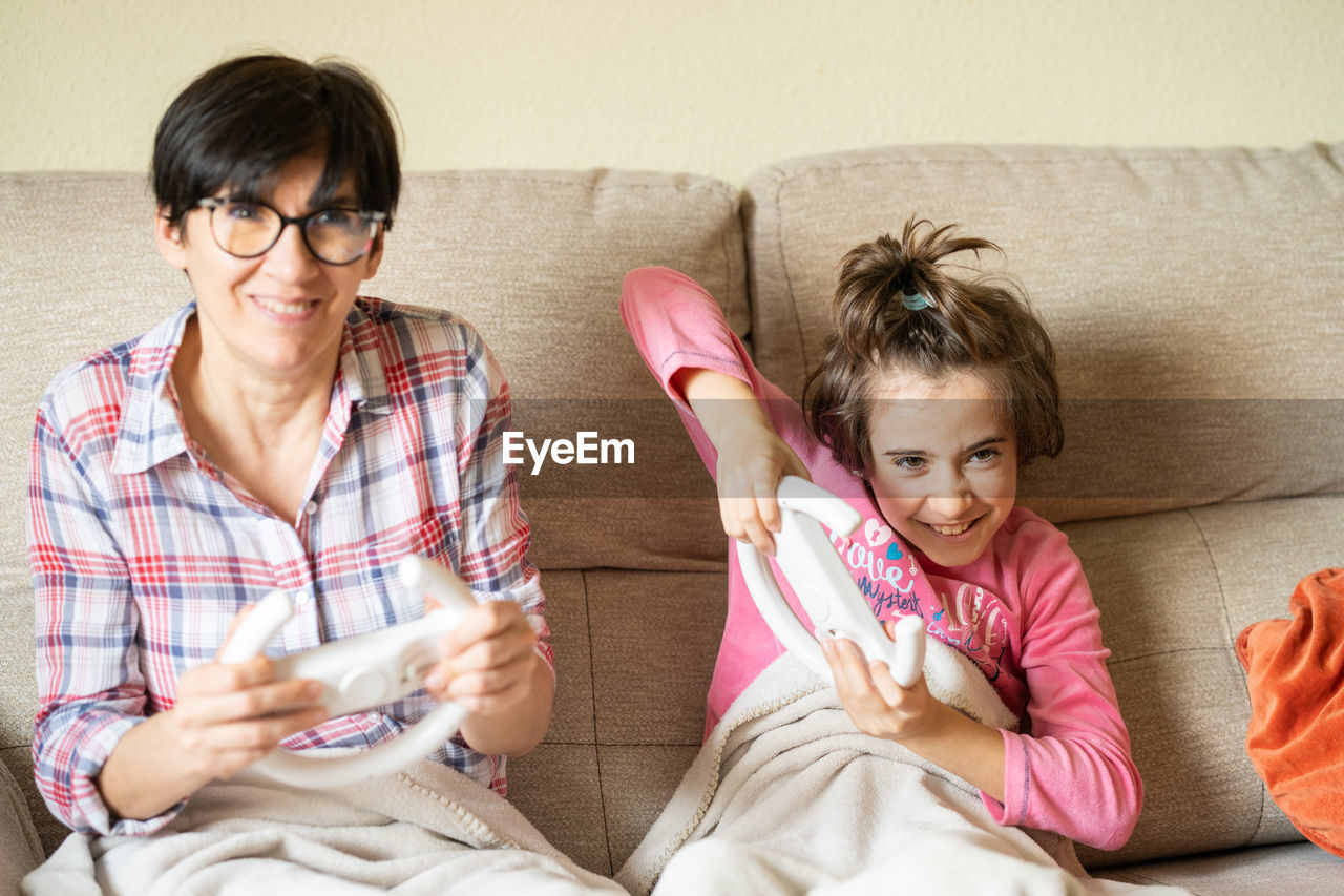 WOMEN SITTING ON SOFA AT HOME