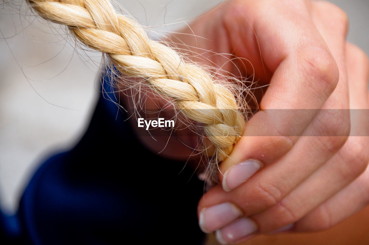 Cropped image of hand holding braided hair