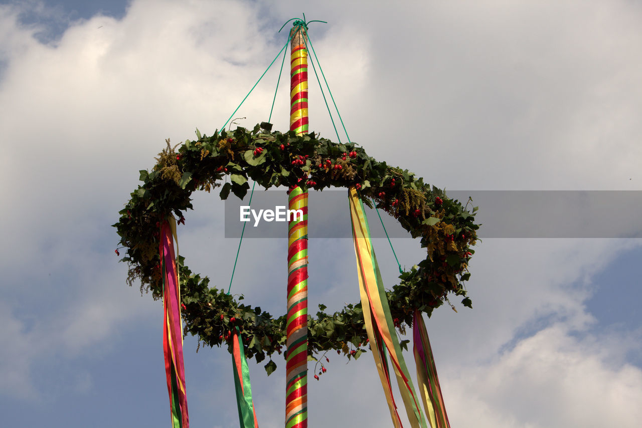 Low angle view of wreath hanging on pole against sky