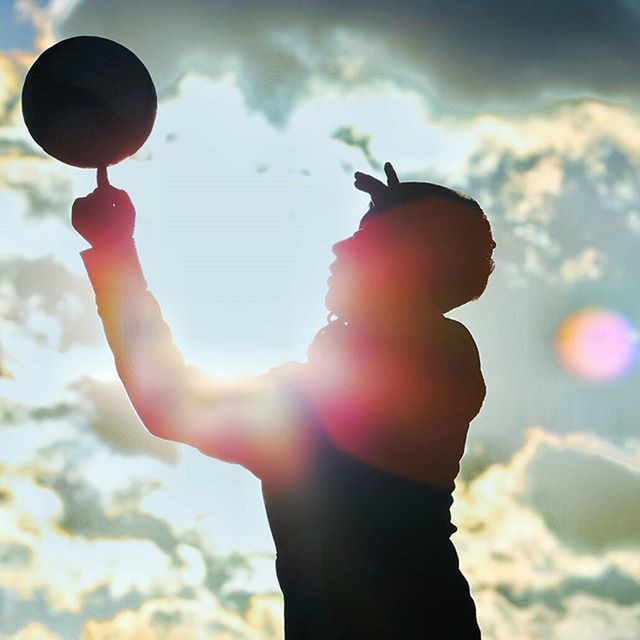 LOW ANGLE VIEW OF PERSON HOLDING UMBRELLA AGAINST SKY