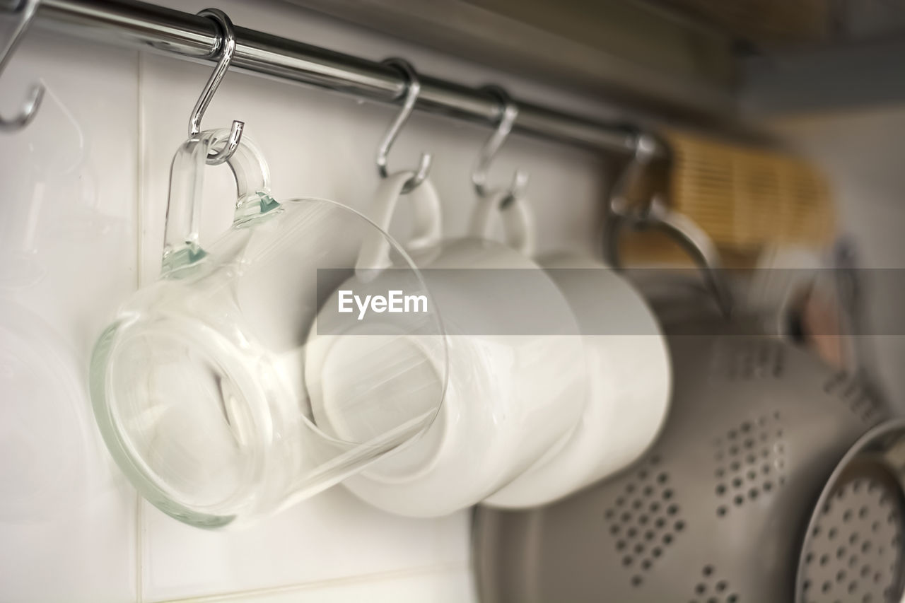 Close-up of crockery hanging on rack in kitchen