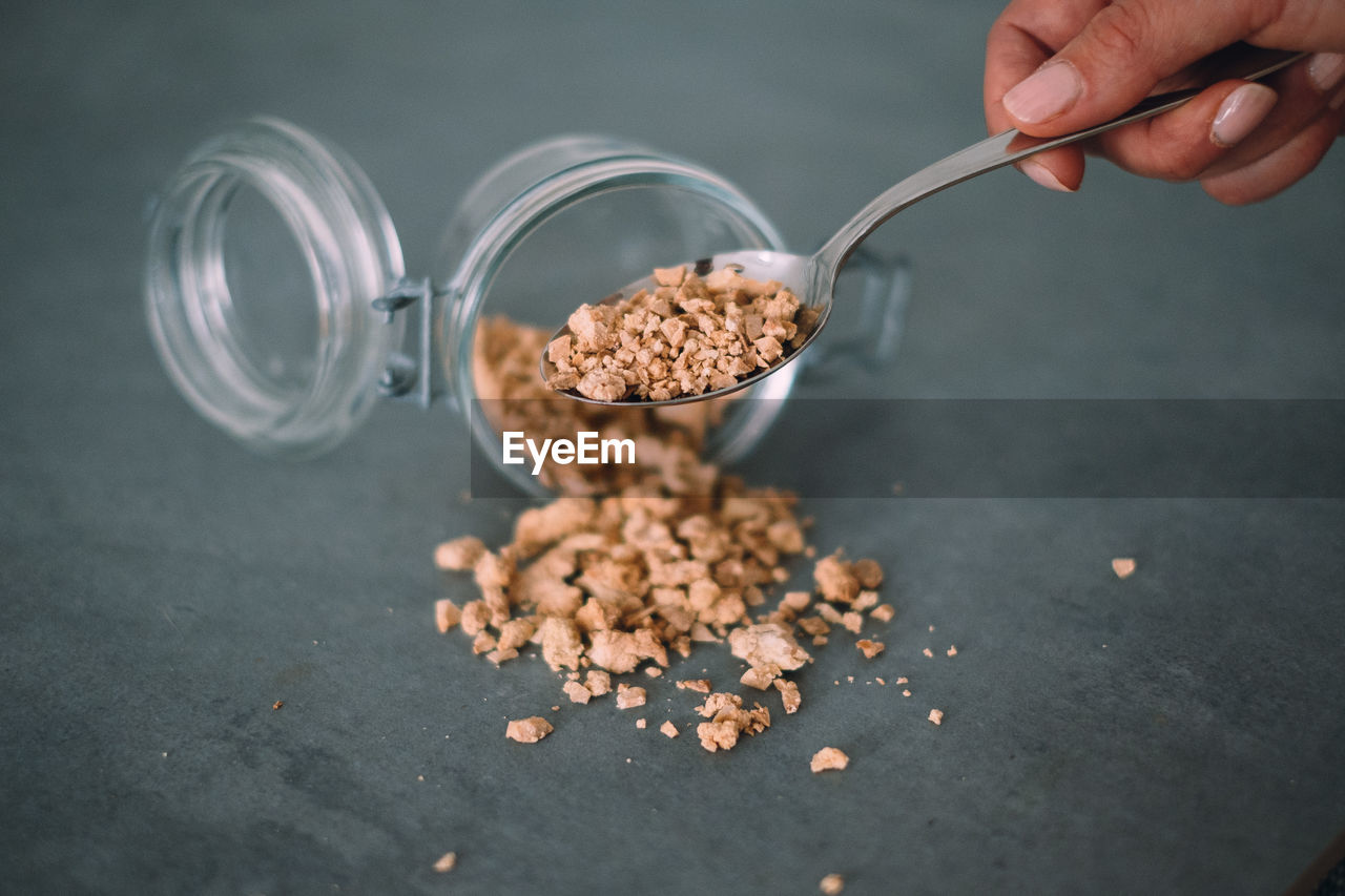 Cropped hand holding spoon with crushed chestnuts