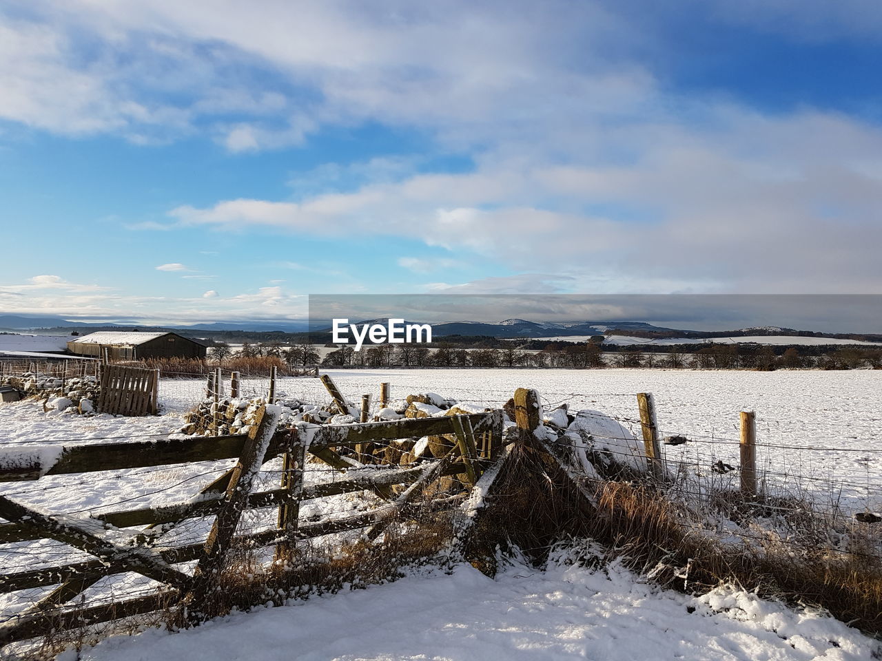 Snow on field against sky during winter